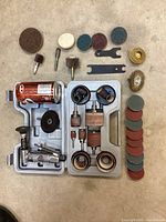 Overview of the Sioux air die grinder with a variety of attachments including sanding discs, grinding tools, polishing heads, wire brush wheel, and two small adjustment wrenches. All arranged in a molded plastic case.
