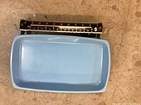 Close-up photo of blue weighing tray and black balance beam with measurement markings.