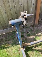 Side view of the blue engine stand showing mounting brackets and adjustment screws