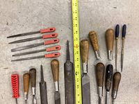 Overview of files and rasps with wooden and plastic handles next to a measuring tape showing lengths about 12 to 13 inches