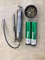 Full lot showing grease gun, two tubes of Esso Unirex grease, and container of grease fittings