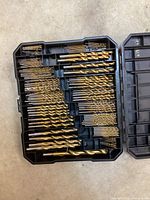 Top view of open case showing multiple rows of assorted drill bits in various sizes organized in compartments