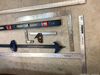 Close-up top view of the group of measuring tools focusing on the spirit level, combination square and rulers