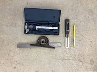 Lot overview showing all four items: digital calipers in case, sliding bevel square, combination square, and reamer.