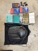 Overview of all items in the lot including face shield, drill bits in packaging, welding helmet lens, drill bit index chart, and small accessories.