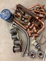 Copper pipes and fittings with solder paste and supply hoses on floor