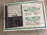 Box showing product image and specifications for Micronta Range Doubler Multitester 22-204C.