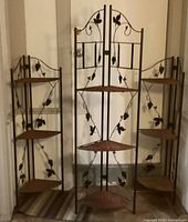 Three folding metal corner shelf units in a row, showing two smaller matching units and one taller unit in the middle.