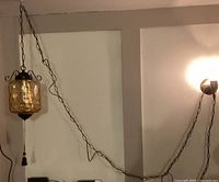 Photo showing the orange bubble glass swag light hanging with wrought iron chain and metal holders.