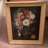 Full view of the framed oil painting showing the large flower vase and miniature lady figure next to it