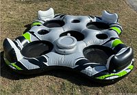 Full view of the Ozark Trail 4-person inflatable float showing four mesh seats, two backrests, and green/black accents.