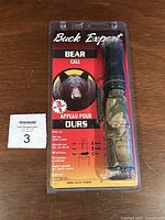 Buck Expert Bear Call in original blister packaging showing branding, bear image, and details about the calls it can mimic.