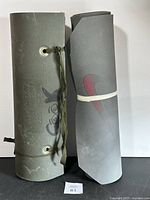 Both foam mats rolled and standing upright, showing Nike logo on one and grommets on the other