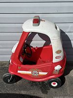 Side view of red and white Little Tikes Fire Company kids ride-on car showing decals and roof light.