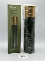Thermos standing wrapped in plastic beside its olive green branded Olympia box showing the item image and product details.