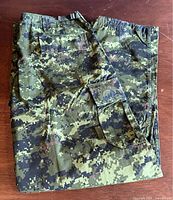 Folded CADPAT digital camouflage combat pants showing overall pattern and pockets.