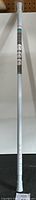 Full length view of the silver aluminum True Living Super Grip Shower Rod with adjustable length markings and rubber ends.