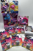 Photo showing the lot of assorted toys including large blue unicorn, pink My Little Pony musical toy, multiple Trolls figures, and Frozen II jewelry box.