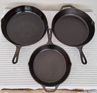 Top view of three cast iron pans: two 10-inch skillets (one Lodge, one unknown maker) and one 8-inch Lodge skillet.