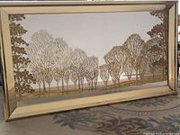Full front view of large gold framed mirror with etched trees