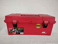 Closed red Plano 20-inch toolbox showing front and latches with labels.