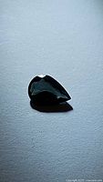 Pear cut blue green sapphire gemstone, 0.64ct, shown with polished surface and pear shape.