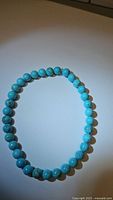 Full view of the natural turquoise stretchy bracelet with robin's egg blue round beads, arranged in a circle on a plain white background.