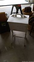 White wooden yarn or sewing holder on a pedestal stand, closed lid