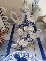 All three teapots arranged on table showing size difference and detailed painting
