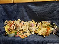 Wide shot of the lot showing various Easter and spring decorative items including ceramic, fabric, and painted figures, plates, and signs.