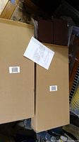 Two boxed raised garden bed side panels with assembly instruction sheet on top