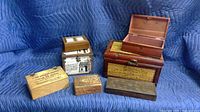 Overview photo of six trinket boxes showing variety of materials: wood, metal, tin, woven. Boxes range in size from small to medium.