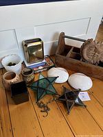 Shows assortment of planters including white hobnail milk glass, brown ceramic, brass vase, wooden caddy, star-shaped stained glass votive holders, and two white ceramic pocket vases on floor.