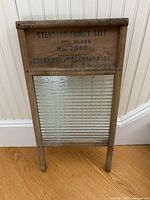 Full front view of vintage glass washboard with branding and measurements visible