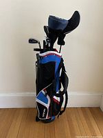 Full view of Top-Flite junior golf bag standing upright filled with 7 clubs with some head covers attached.