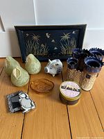 Overview of all items showing candles, tray with nature design, amber glass dish, candle holders, piggy bank, and frames