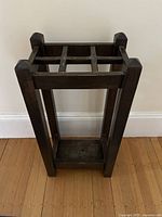 Full front view of the wooden umbrella stand showing its structure and design.