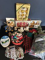 Full overview of all Christmas lot items including candleholders, ornaments, tins, wooden pyramid, Advent calendar, and greenery.