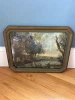 Photo showing the full frontal view of the vintage framed landscape print resting against the wall and floor, highlighting overall composition and frame detail.