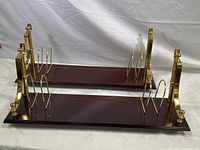 Pair of wooden shelves with brass posts and bookends shown horizontally against a white background.