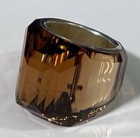 Close-up front angle view of the Swarovski topaz glacier ring showing the large faceted topaz crystal with warm amber hues on a silver-toned band.