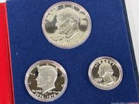 Close-up photo of the three silver proof coins showing detailed obverse profiles and bicentennial dates 1776-1976, each in protective capsules.