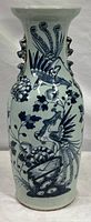 Full front view showing entire height and underglaze blue bird and flower design on celadon ground.