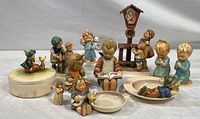 Photo of the entire collection including all figurines, covered dish, and ashtrays shown together.