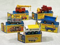 Front view of all five vintage Matchbox model vehicles and their boxes arranged on white surface, showcasing the complete lot.