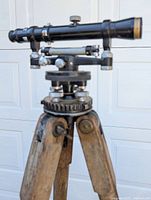 Close-up of transit scope and leveling mechanism on tripod