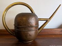 Front-on view of the hammered copper body, handle and spout.