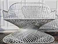 Front view of white woven lattice fiberglass bench against garage door