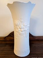 Front view of Kaiser bisque porcelain vase showing textured raised floral relief and scalloped rim.
