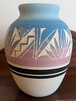 Front view of Navajo pottery vase showing gradient color glaze and carved abstract designs.
